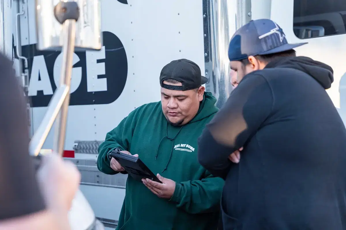 Two All My Sons team members review a moving checklist outside of a moving truck.