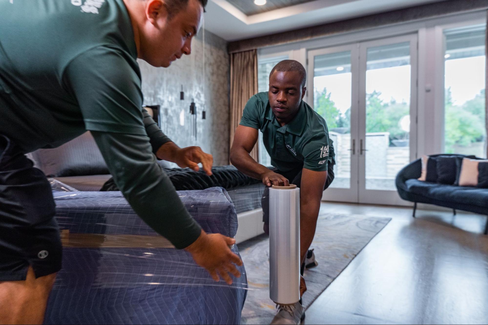 All My Sons professional movers wrap an ottoman for transport.