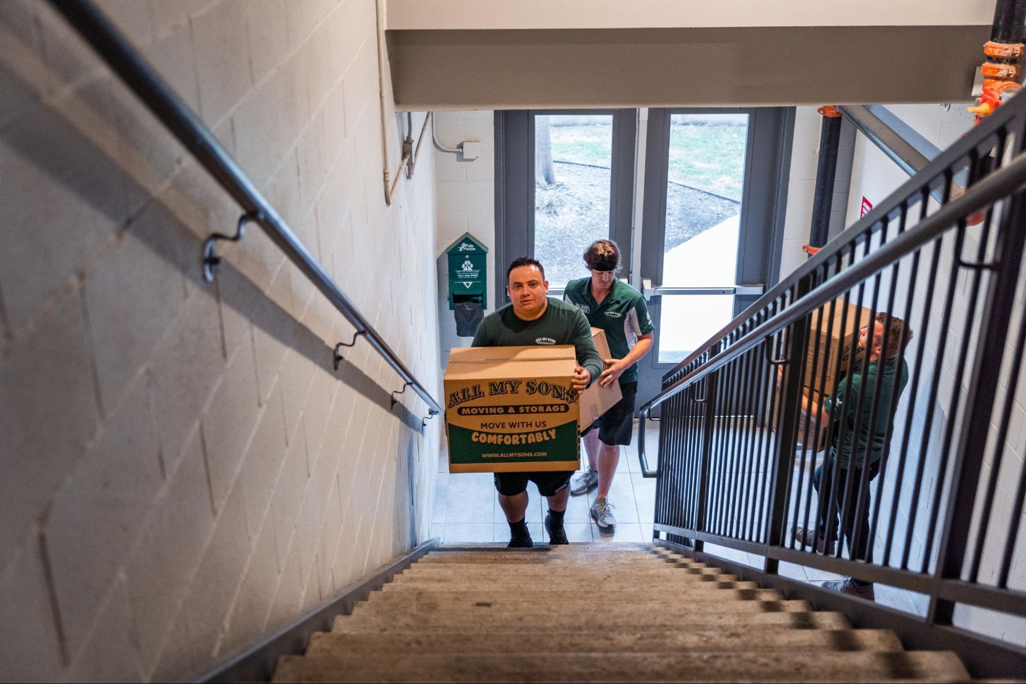 All My Sons professional movers navigate up a narrow staircase to perform an apartment move.
