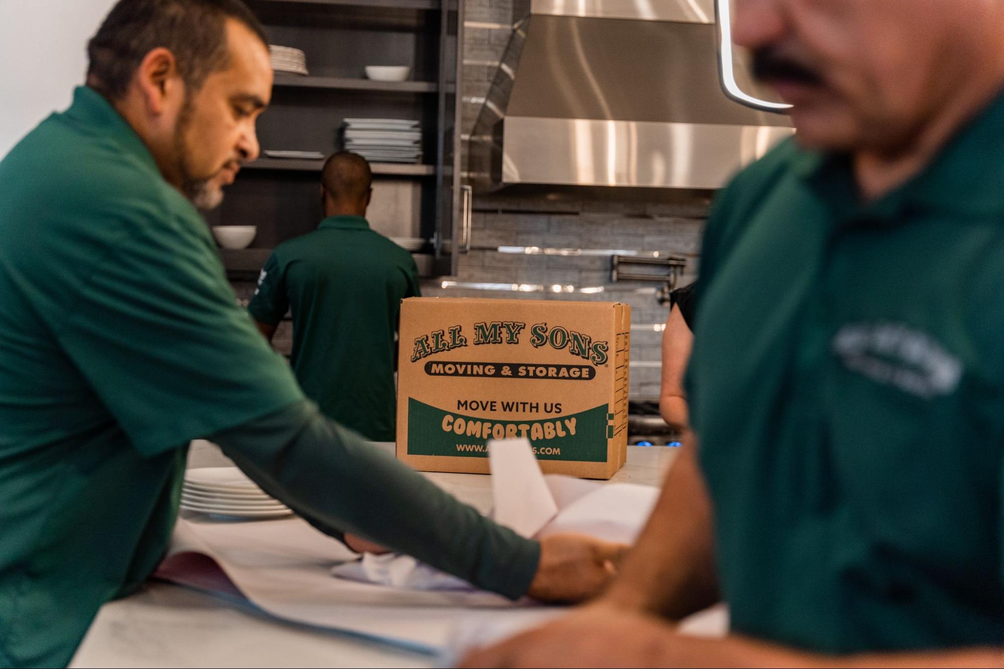 All My Sons professional packers wrap plates to put into moving boxes.